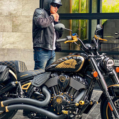 Custom Indian Motorcycle with black and gold handcrafted parts outside Lawless Garage Quebec, rider in helmet